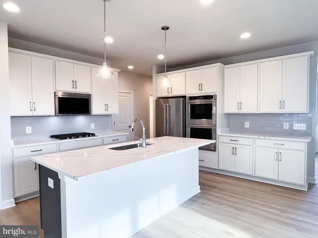 a kitchen with a stove a sink and a refrigerator