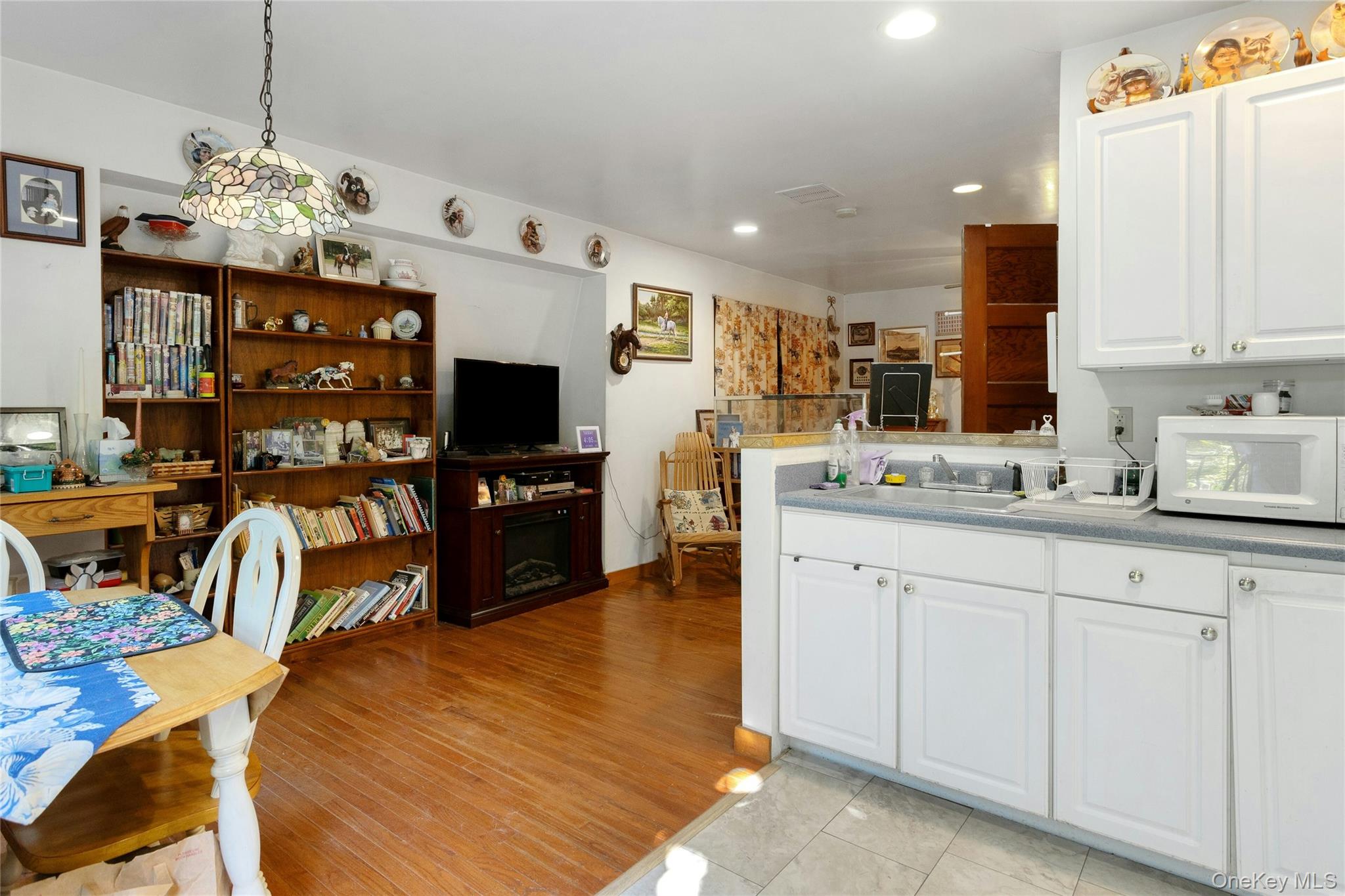 73 Lake Ellis Road Wingdale, NY 12594 - Photo 7 of 41 Kitchen featuring white cabinets, white microwave, hanging light fixtures, recessed lighting, and light countertops