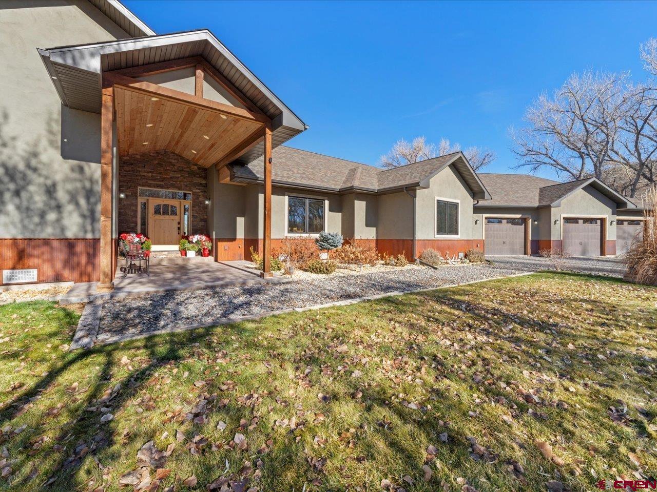 a front view of a house with a yard outdoor seating and garage