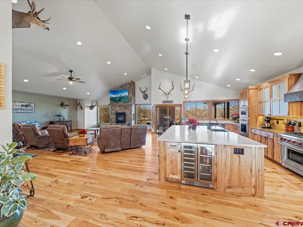 7528 South River Road Olathe, CO 81425 - Photo 11 of 44 a large kitchen with stainless steel appliances kitchen island granite countertop a large kitchen island and a view of living room