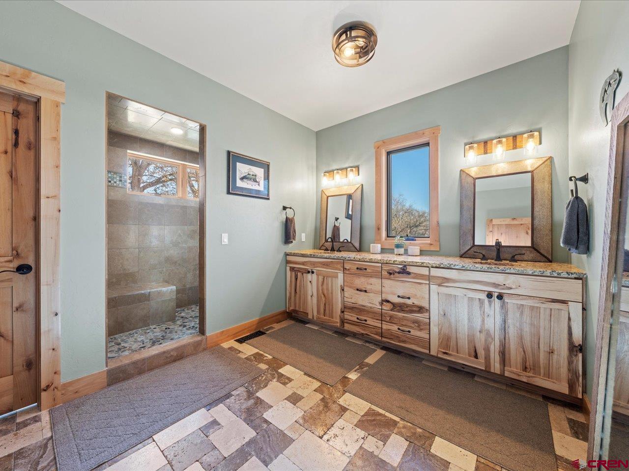 7528 South River Road Olathe, CO 81425 - Photo 19 of 44 a bathroom with a sink a mirror and a shower