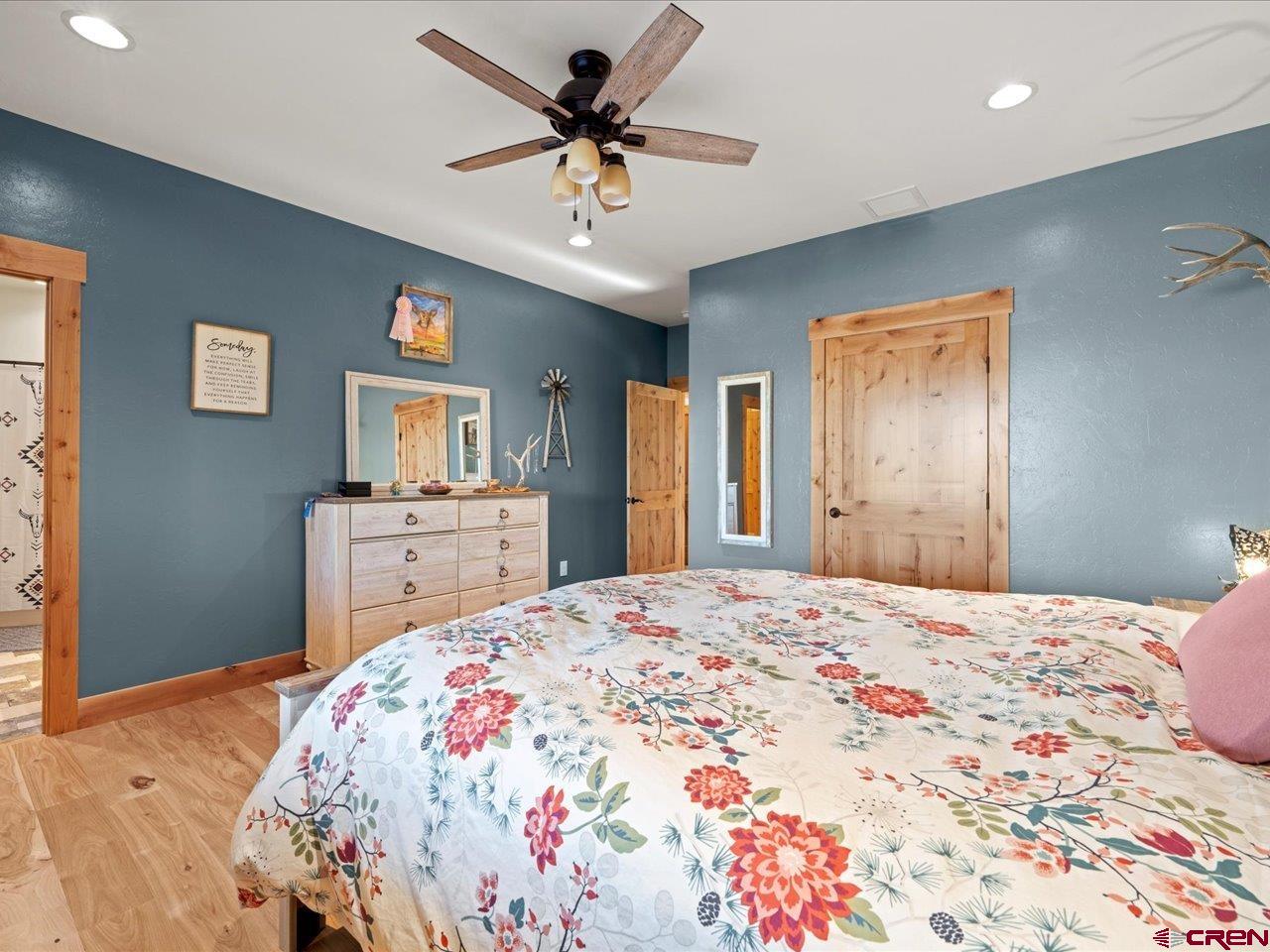 7528 South River Road Olathe, CO 81425 - Photo 26 of 44 a bedroom with a large bed and a chandelier