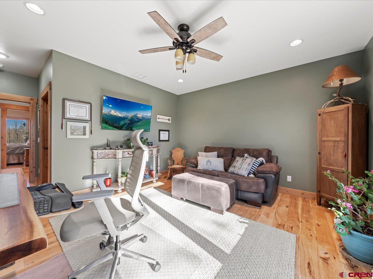 7528 South River Road Olathe, CO 81425 - Photo 30 of 44 a living room with furniture a flat screen tv and a chandelier