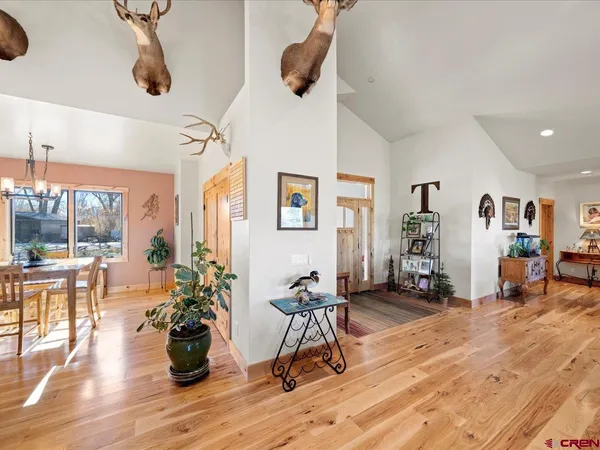 a dining room with furniture a chandelier and wooden floor