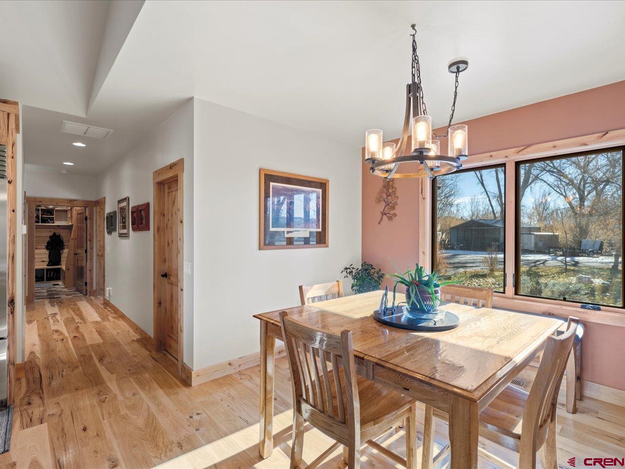 7528 South River Road Olathe, CO 81425 - Photo 7 of 44 a dining room with furniture a chandelier and wooden floor