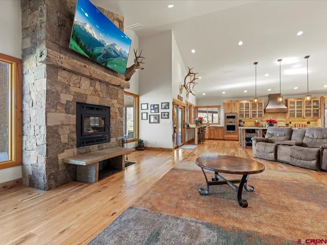 a large kitchen with stainless steel appliances kitchen island granite countertop a large kitchen island and a view of living room