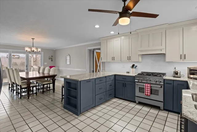 a kitchen with stainless steel appliances a stove a sink a dining table and chairs