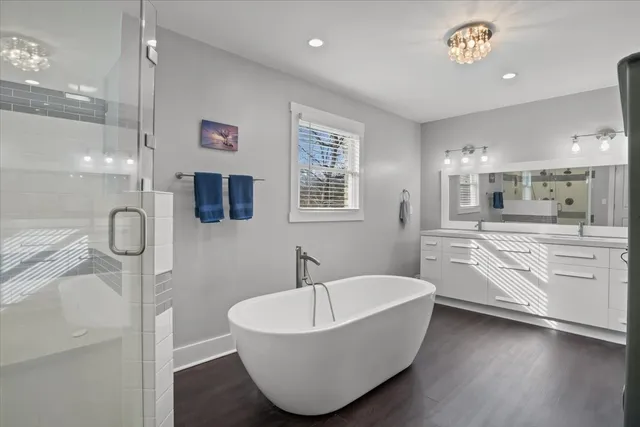 a spacious bathroom with a bathtub sink and a mirror