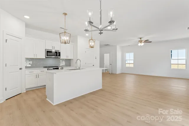 a view of kitchen with granite countertop stove top oven and cabinets
