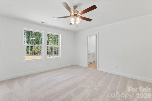 an empty room with a chandelier fan