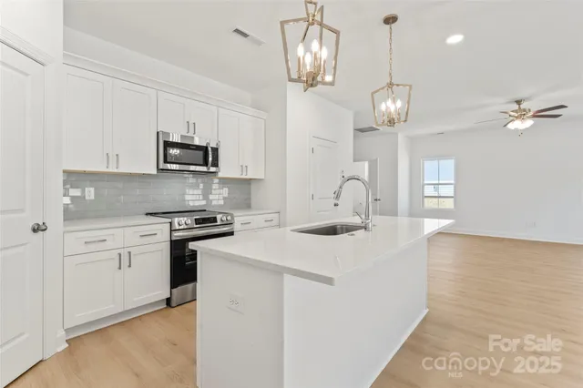 a kitchen with kitchen island granite countertop appliances cabinets and a counter top space