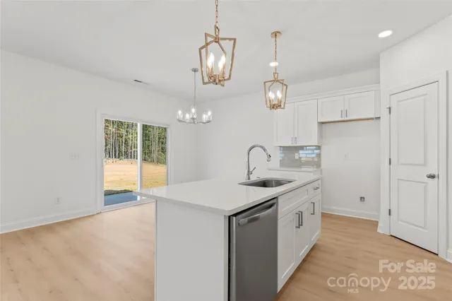 a kitchen with a sink chandelier and stove