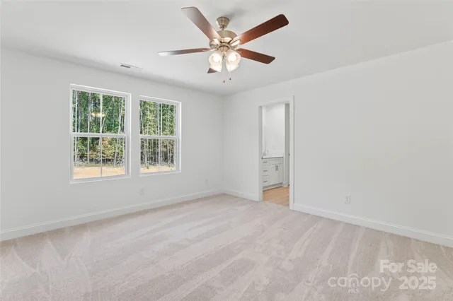 an empty room with window and ceiling fan