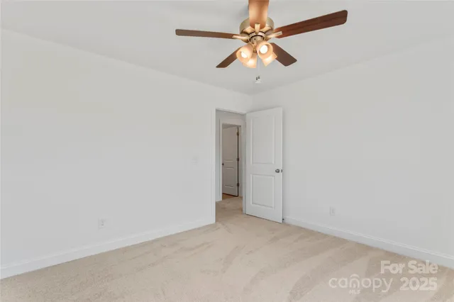 an empty room with a chandelier fan and a ceiling fan