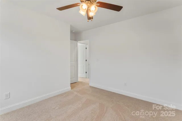 an empty room with a chandelier fan
