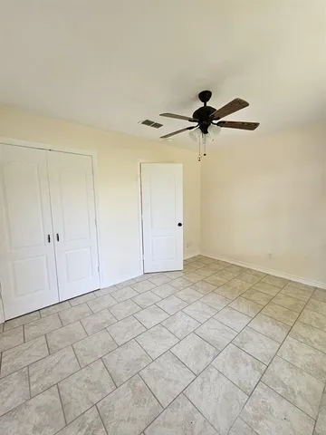 a view of a room with a ceiling fan and carpet