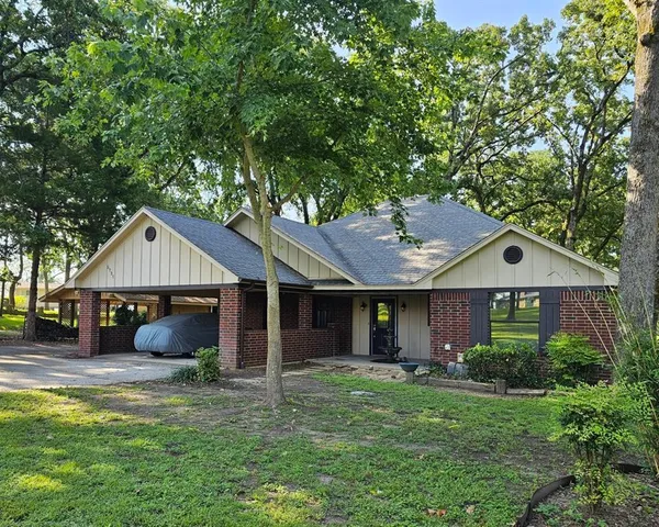 a front view of a house with a garden and yard