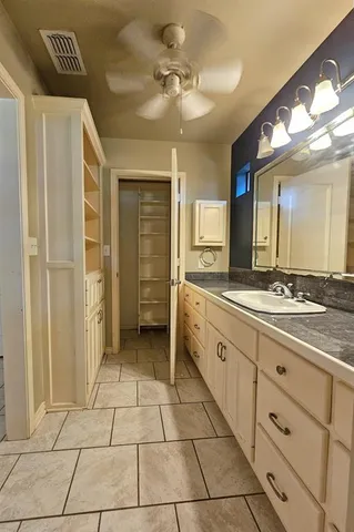 a spacious bathroom with a double vanity sink a mirror and a shower