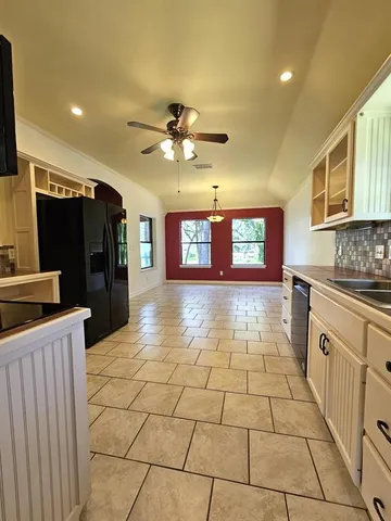 a large kitchen with stainless steel appliances a stove a sink and a refrigerator