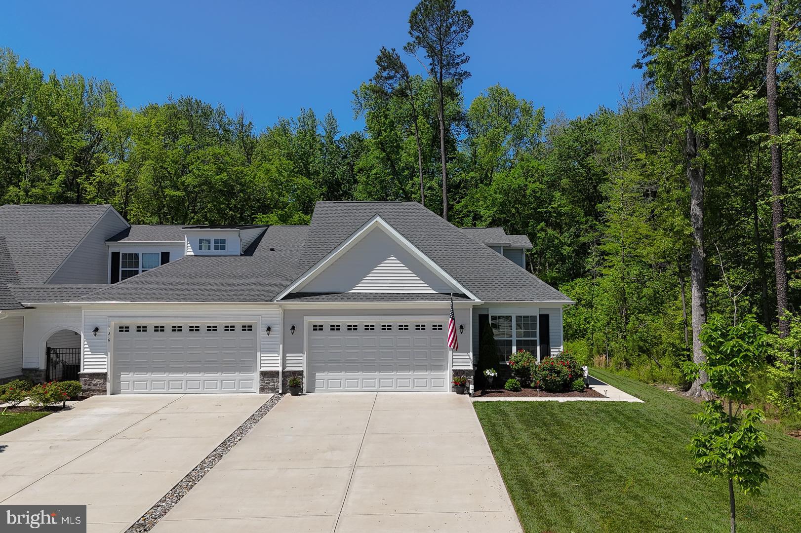 a front view of a house with a garden and trees