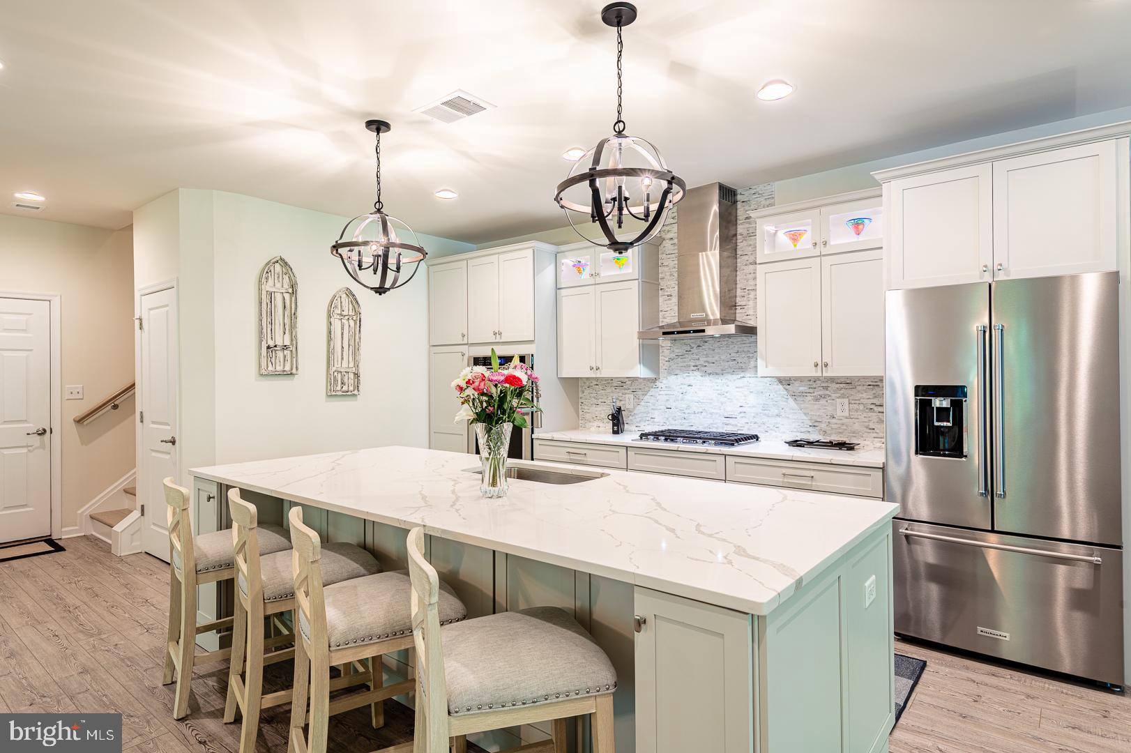 314 Tranquility Way Middletown, DE 19709 - Photo 11 of 56 a kitchen with stainless steel appliances granite countertop a sink a refrigerator and chandelier