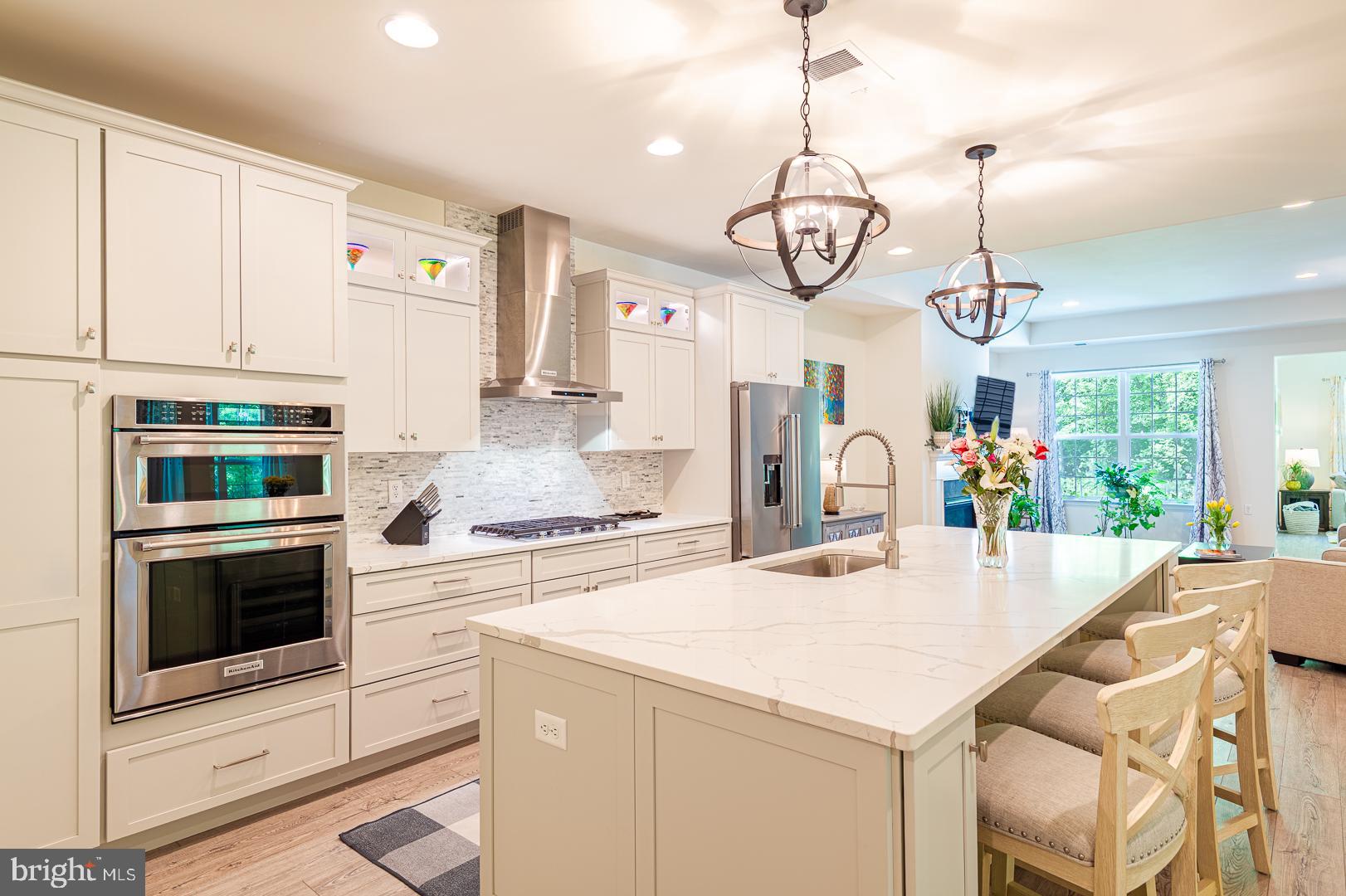 314 Tranquility Way Middletown, DE 19709 - Photo 15 of 56 a kitchen with a table chairs stove and microwave