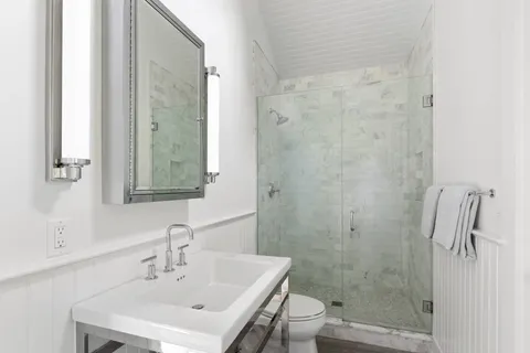 a bathroom with a sink a toilet and shower