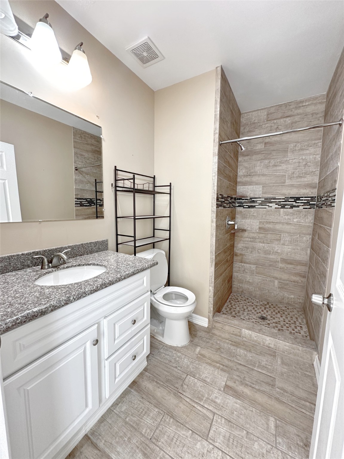 4146 Brinkley Street Houston, TX 77051 - Photo 6 of 9 a bathroom with a granite countertop toilet a sink and a shower