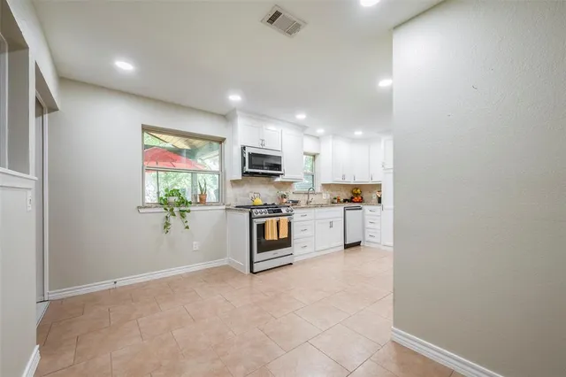 a kitchen with stainless steel appliances a refrigerator sink and stove