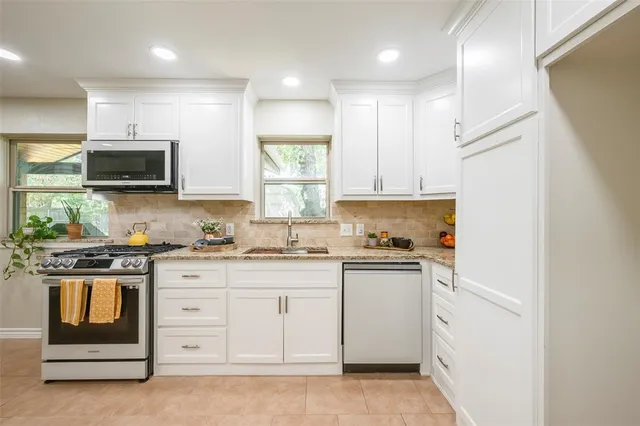 a kitchen with stainless steel appliances granite countertop a stove and a sink