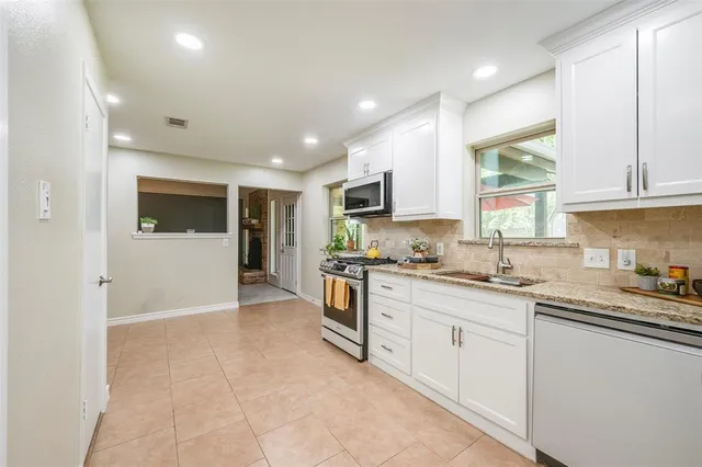 a kitchen with stainless steel appliances granite countertop a stove sink and cabinets