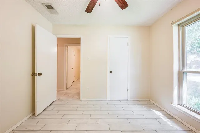 an empty room with windows and closet
