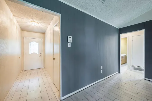 a view of a hallway with wooden floor and a bathroom