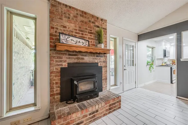 a view of a livingroom with a fireplace wooden floor and a window