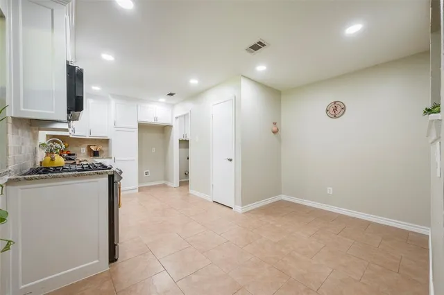 a view of kitchen with refrigerator stove and wooden cabinets