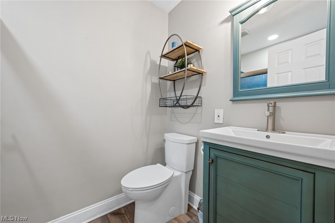 2425 McMackin Road Madison, OH 44057 - Photo 23 of 46 Bathroom with vanity, toilet, and hardwood / wood-style flooring