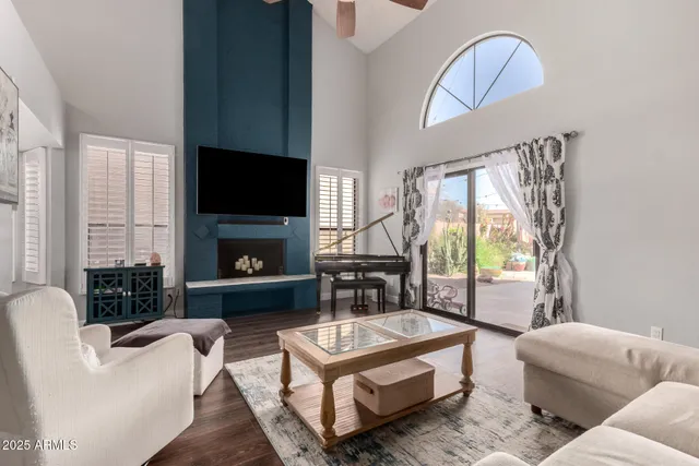 a living room with furniture a flat screen tv and a fireplace