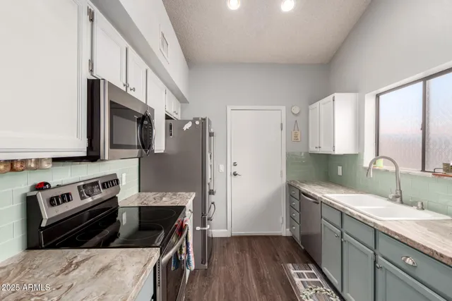 a kitchen with a sink stove top oven and cabinets