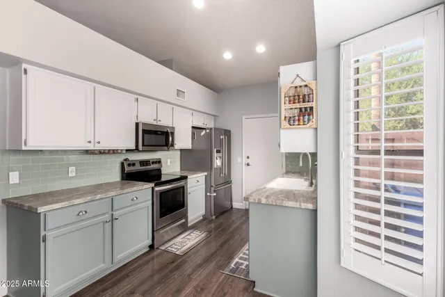 a kitchen with granite countertop white cabinets and appliances