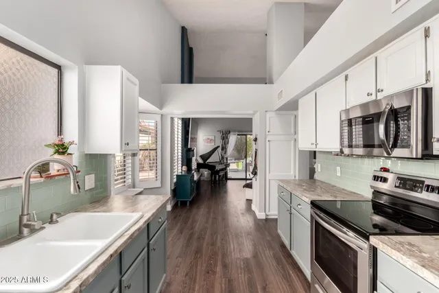 a kitchen with stainless steel appliances a stove sink microwave and cabinets