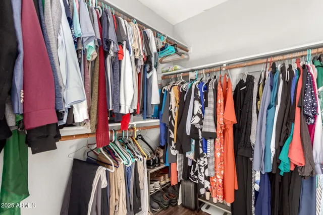 a view of walk in closet with clothes