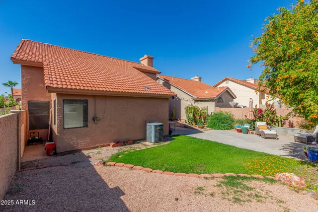 a view of a house with backyard and sitting area