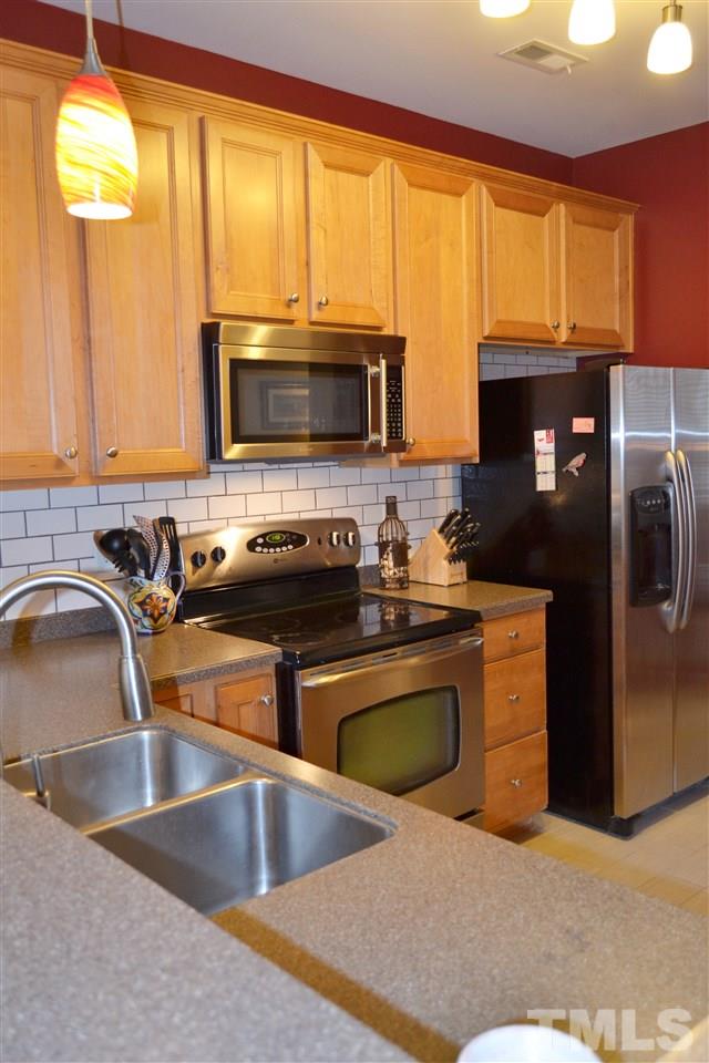 7840 Silverthread Lane Raleigh, NC 27617 - Photo 12 of 21 a kitchen with stainless steel appliances granite countertop a stove a sink and a microwave