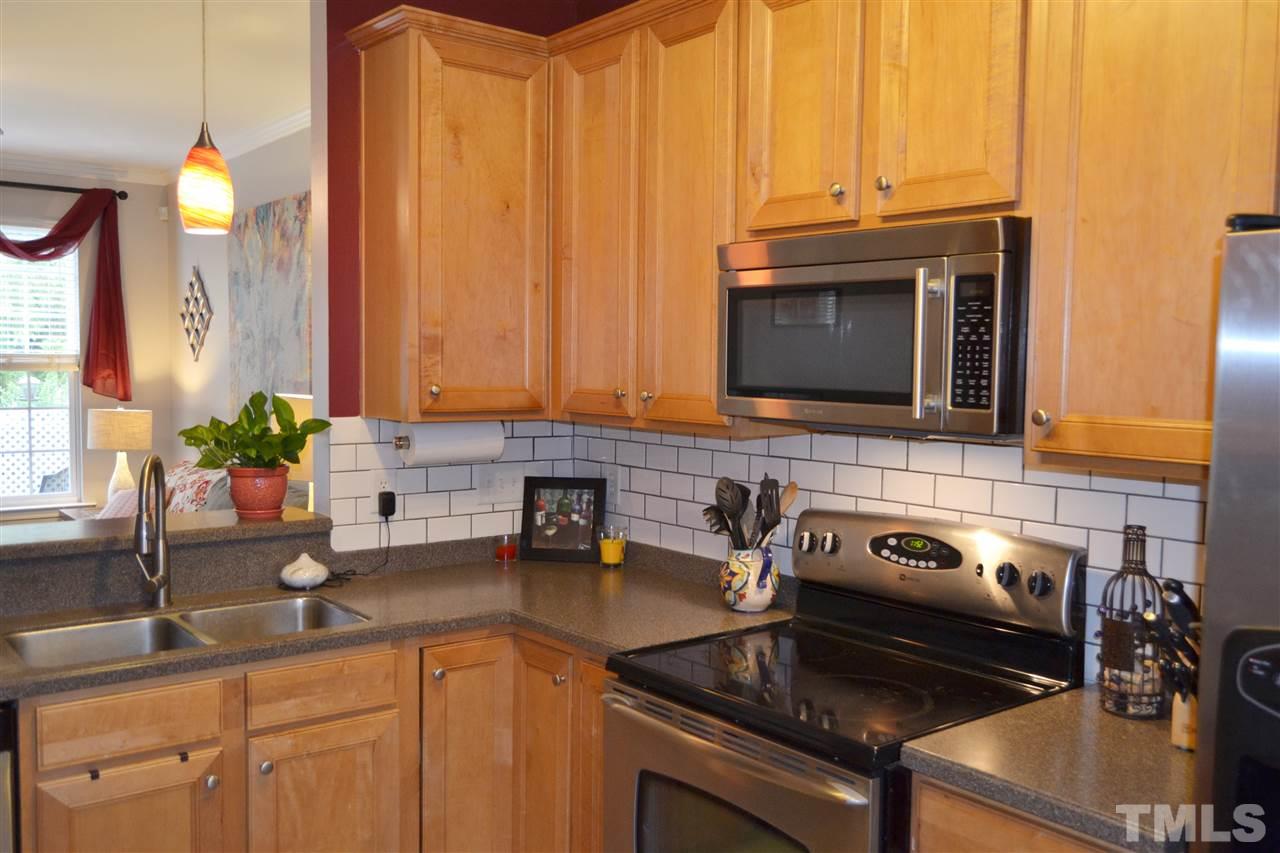 7840 Silverthread Lane Raleigh, NC 27617 - Photo 13 of 21 a kitchen with granite countertop a sink a stove and cabinets