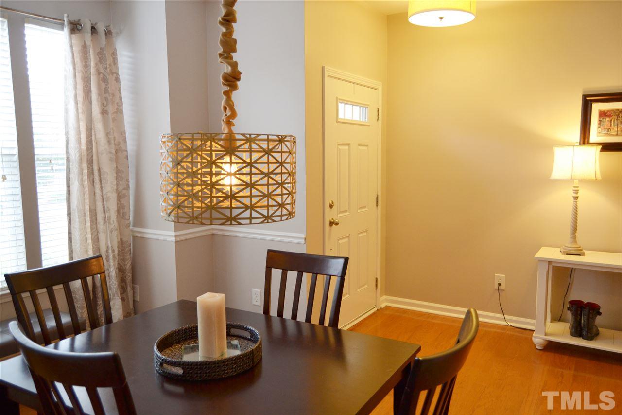 7840 Silverthread Lane Raleigh, NC 27617 - Photo 14 of 21 a view of a dining room with furniture a chandelier and wooden floor