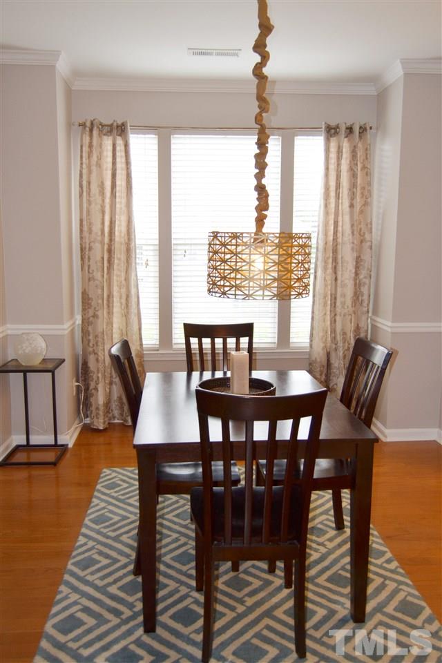 7840 Silverthread Lane Raleigh, NC 27617 - Photo 15 of 21 a view of a dining room with furniture window and wooden floor