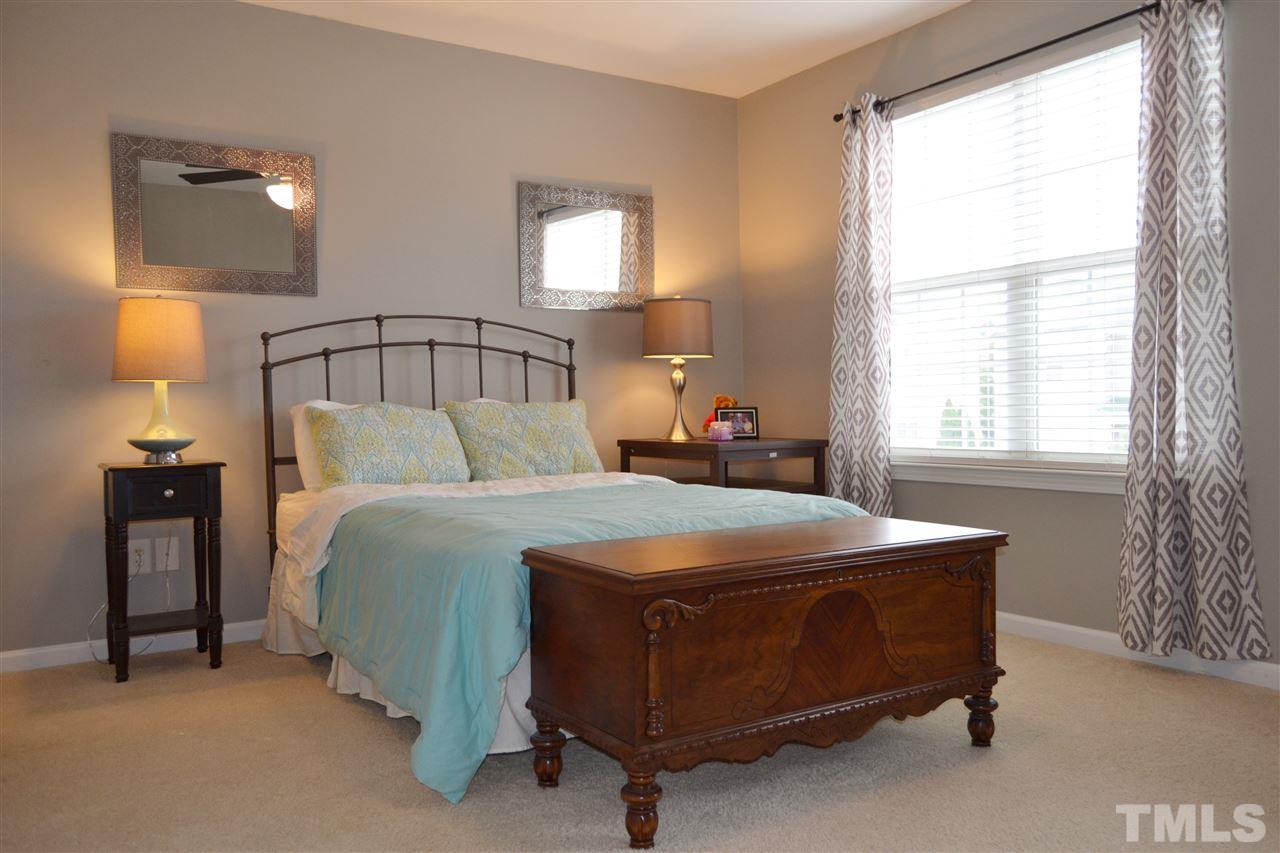 7840 Silverthread Lane Raleigh, NC 27617 - Photo 18 of 21 a bedroom with a bed and a lamp