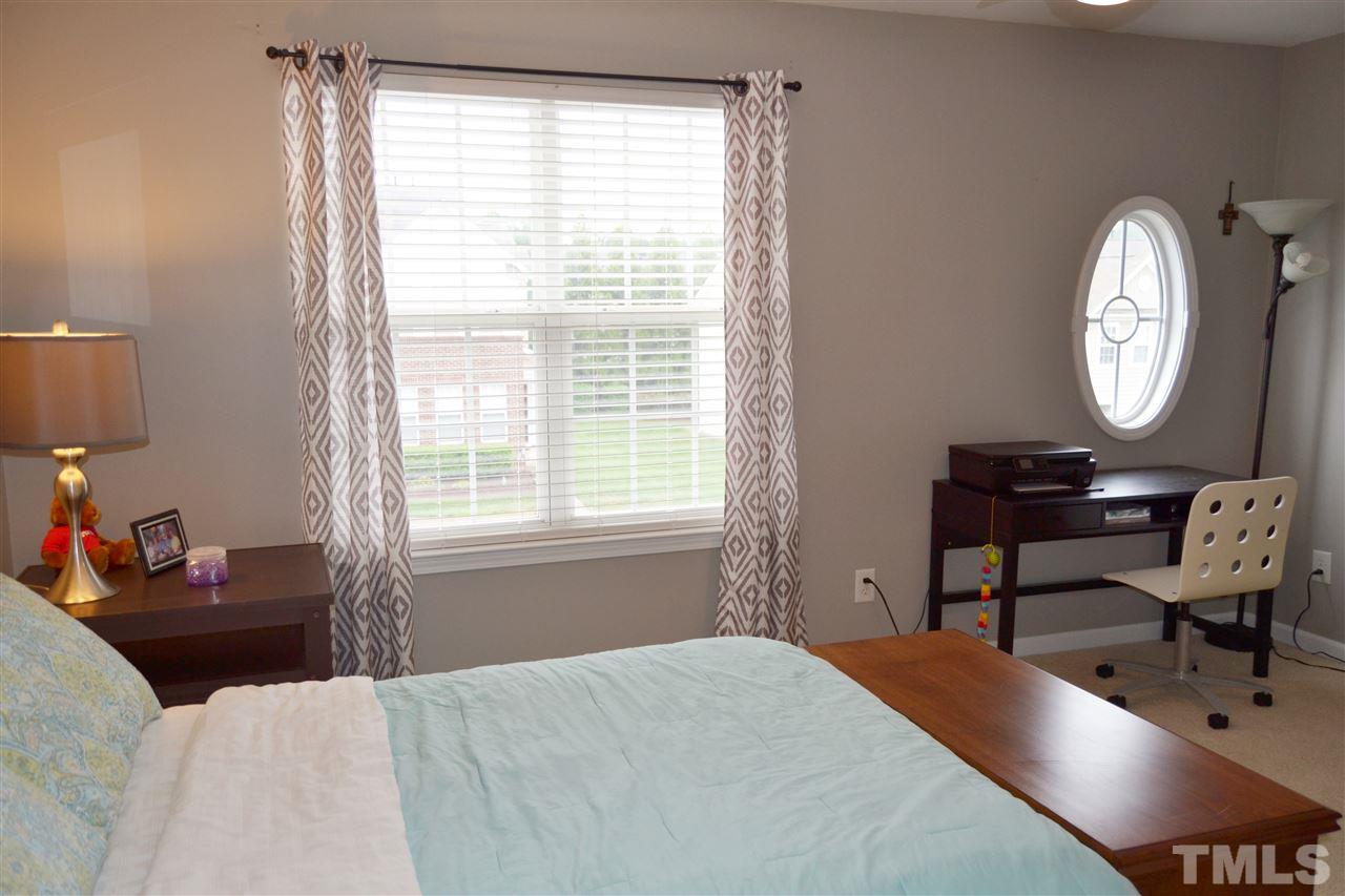 7840 Silverthread Lane Raleigh, NC 27617 - Photo 19 of 21 a bedroom with a bed a chair and a large window
