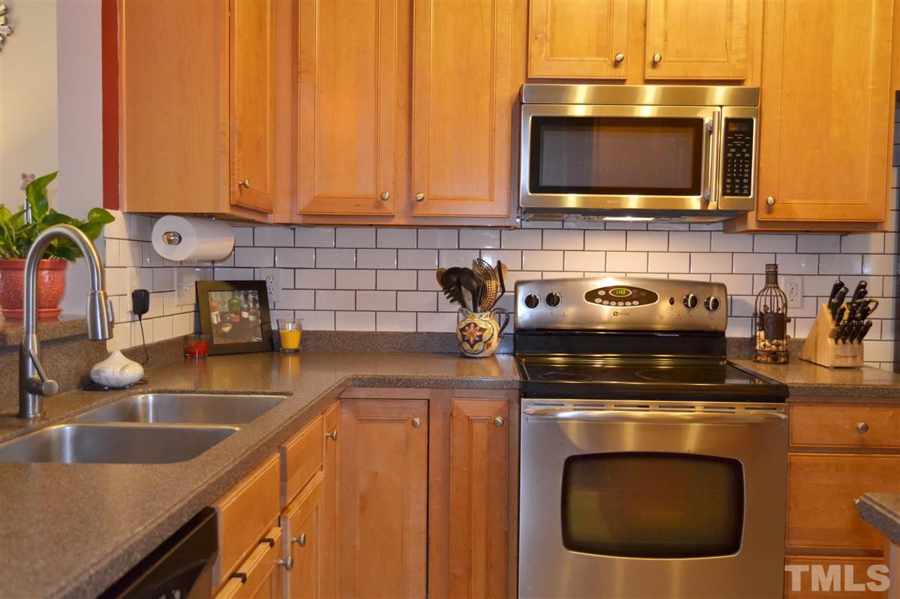 7840 Silverthread Lane Raleigh, NC 27617 - Photo 3 of 21 a kitchen with a sink a stove and cabinets