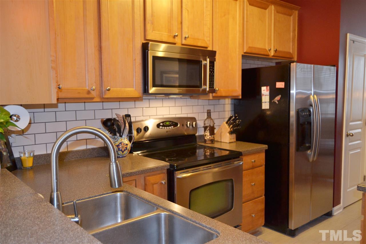 7840 Silverthread Lane Raleigh, NC 27617 - Photo 10 of 21 a kitchen with a sink and a stove top oven with wooden floor
